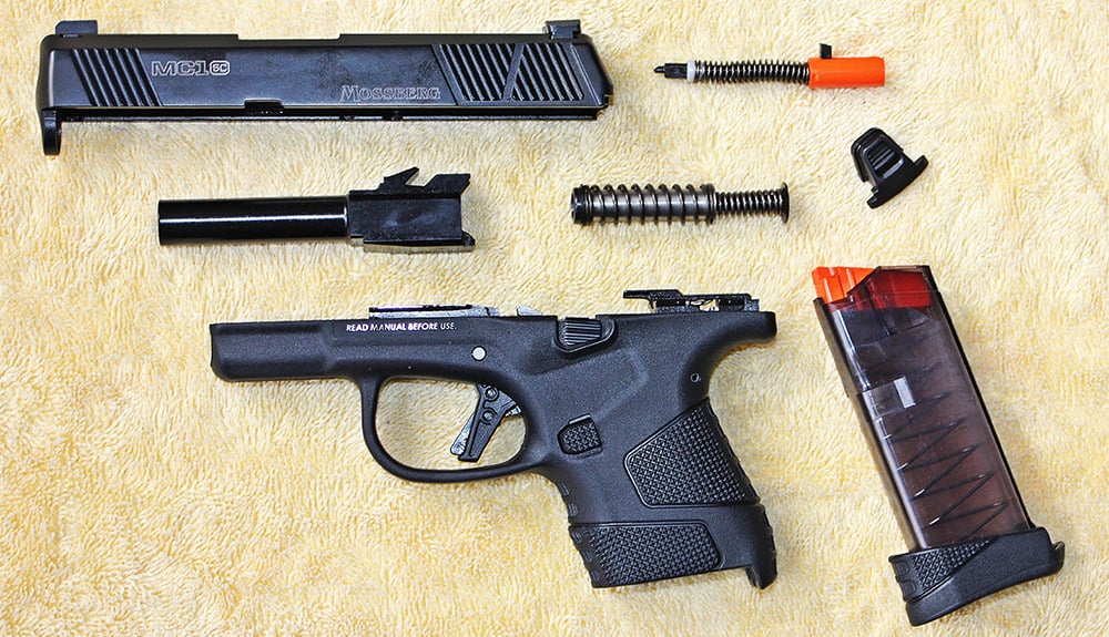 MC1sc disassembled into 7 basic components, clockwise from top left; slide, striker assembly, slide cover plate button, 7-round extended magazine, frame, barrel, and center; recoil spring assembly.