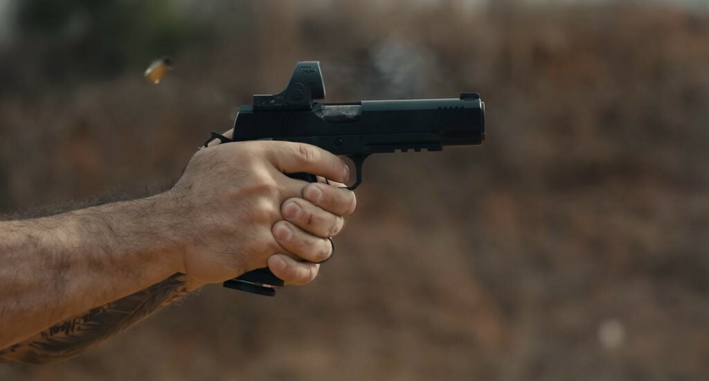 a man shooting a kimber warrior double stack